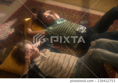 Boys Relaxing on Rug with Vintage Music Player Boys Relaxing on Rug with Vintage Music Player 116422753