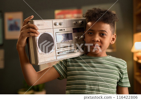 Portrait of African American Boy Holding Boombox in Living Room 116422806