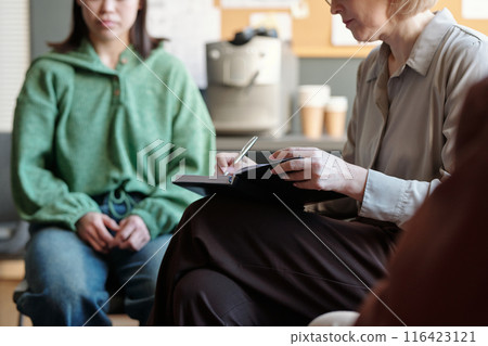 Psychologist making notes in notepad 116423121