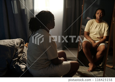 Depressed woman in front of mirror 116423158