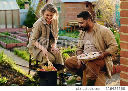 Two farmers bending over hot frying pan Two farmers bending over hot frying pan 116423368