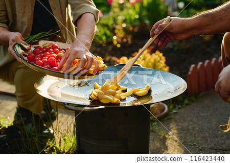 Couple frying chopped potatoes together 116423440