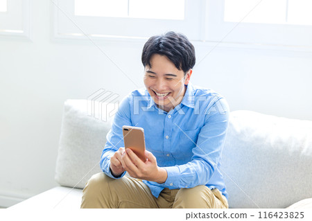 一個年輕人笑著打視訊電話 一個年輕人笑著打視訊電話 116423825