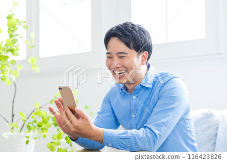 Smiling young man making a video call Smiling young man making a video call 116423826