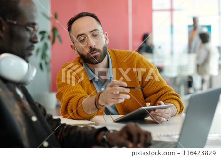 Caucasian and Black Colleagues Collaborating on Project in Office Caucasian and Black Colleagues Collaborating on Project in Office 116423829