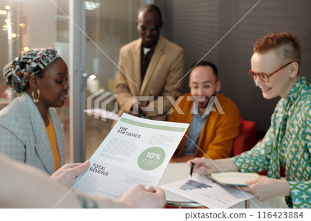 Multiracial Team Reviewing Statistics during Business Meeting 116423884