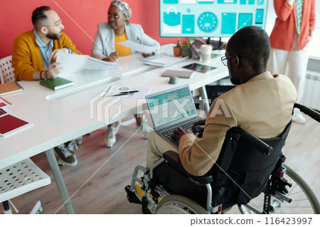 Black Man in Wheelchair Using Laptop during Meeting 116423997