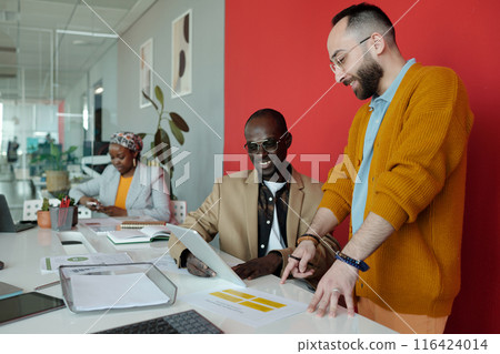 Diverse Colleagues Working on Digital Project in Office 116424014