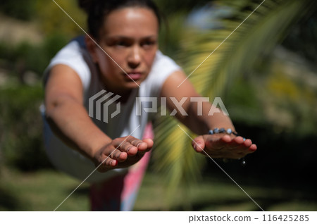 Woman practicing yoga outdoors in a focused and balanced pose Woman practicing yoga outdoors in a focused and balanced pose 116425285