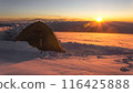 Lone tent on snowy Mount Elbrus at sunrise, climber solo travels in extreme winter conditions, explores alpine landscape amid snow storm, adventure, challenge 116425888