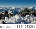 Solo traveler camp on Mount Elbrus summit. Lone tent in snow, rocks, extreme mountain backdrop. Adventurous climber gear on rugged terrain, with breathtaking views. 116425891