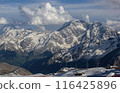 Caucasus Range at sunset with snow-capped peaks, clouds hover over rugged terrain. Alpine landscape in soft evening light, tranquil mountaintop scene attracts nature lovers, hikers. 116425896