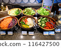 Several salad dishes were placed on the buffet line. 116427500