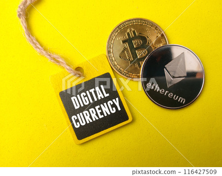 Top view golden bitcoin ,silver ethereum and colored board with text DIGITAL CURRENCY on yellow background. 116427509