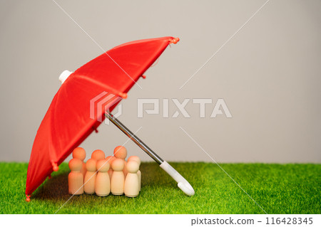 Life insurance concept. Customer and employees care. Security and safety in a business team. Human resources. Social protection. A crowd of wooden figures of men under a red umbrella 116428345