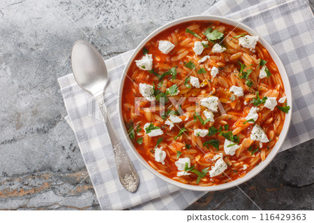 Delicious vegetarian food pasta kritharaki or orzo with spicy tomato sauce, cheese, garlic, onion, carrot closeup on the plate. Horizontal top view Delicious vegetarian food pasta kritharaki or orzo with spicy tomato sauce, cheese, garlic, onion, carrot closeup on the plate. Horizontal top view 116429363