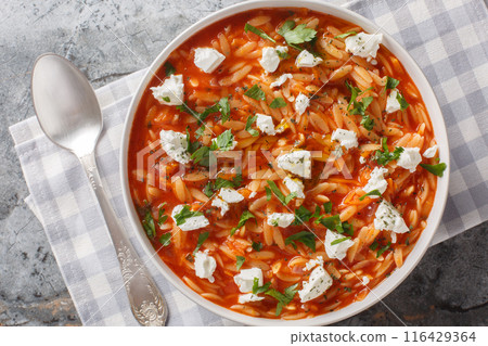 Comfort food pasta kritharaki or orzo with spicy tomato sauce, feta, garlic, onion, carrot closeup on the plate. Horizontal top view Comfort food pasta kritharaki or orzo with spicy tomato sauce, feta, garlic, onion, carrot closeup on the plate. Horizontal top view 116429364