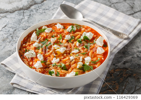 Comfort food pasta kritharaki or orzo with spicy tomato sauce, feta, garlic, onion, carrot closeup on the plate. Horizontal Comfort food pasta kritharaki or orzo with spicy tomato sauce, feta, garlic, onion, carrot closeup on the plate. Horizontal 116429369