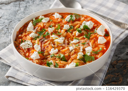 Delicious vegetarian food pasta kritharaki or orzo with spicy tomato sauce, cheese, garlic, onion, carrot closeup on the plate. Horizontal Delicious vegetarian food pasta kritharaki or orzo with spicy tomato sauce, cheese, garlic, onion, carrot closeup on the plate. Horizontal 116429370