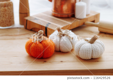 Bright kitchen with wooden furniture with kitchen utensils and three decorative pumpkins. Bright kitchen with wooden furniture with kitchen utensils and three decorative pumpkins. 116429526