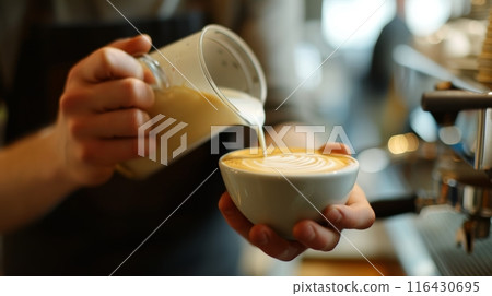 Barista skillfully pouring milk to create latte art on a takeaway coffee cup. 116430695