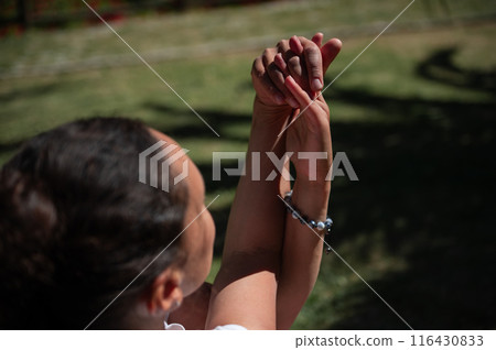 Close-up of clasped hands outdoors symbolizing connection and support 116430833