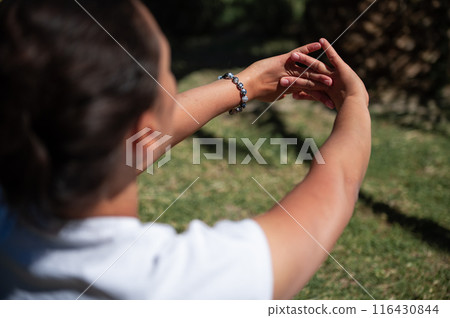 Person practicing mindfulness and yoga outdoors with focus on hands Person practicing mindfulness and yoga outdoors with focus on hands 116430844