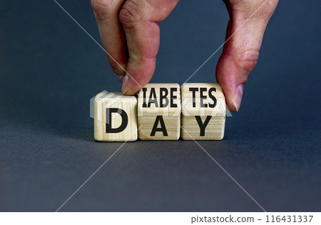 Diabetes day symbol. Concept words Diabetes day on wooden cubes. Doctor hand. Beautiful grey table grey background. Medical and Diabetes day concept. Copy space. 116431337