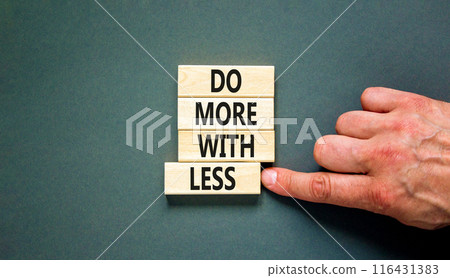 Do more with less symbol. Concept word Do more with less on beautiful wooden block. Beautiful grey table grey background. Businessman hand. Business do more with less concept. Copy space. Do more with less symbol. Concept word Do more with less on beautiful wooden block. Beautiful grey table grey background. Businessman hand. Business do more with less concept. Copy space. 116431383