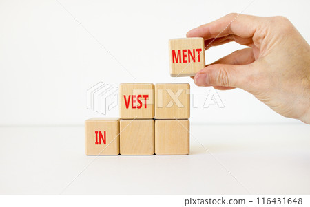 Investment symbol. Concept word Investment on beautiful wooden cubes. Businessman hand. Beautiful white background. Business investment concept. Copy space. 116431648