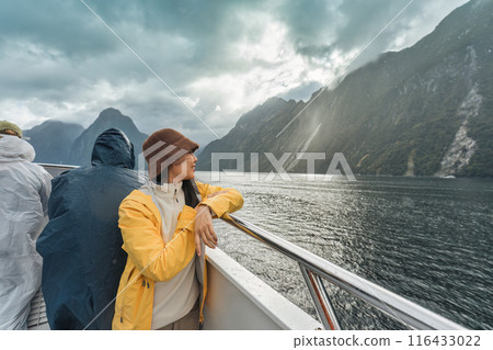 Asian woman enjoying the view of Milford Sound during ferry cruise on vacation at New Zealand Asian woman enjoying the view of Milford Sound during ferry cruise on vacation at New Zealand 116433022