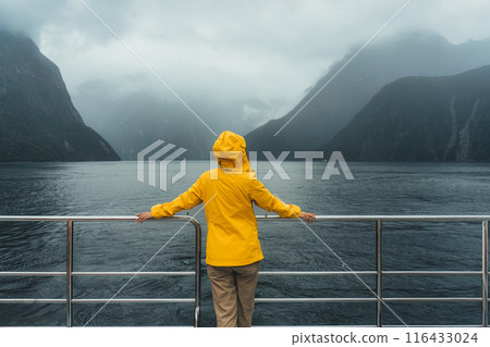 Young female enjoying the view of Milford Sound during ferry cruise on vacation at New Zealand Young female enjoying the view of Milford Sound during ferry cruise on vacation at New Zealand 116433024