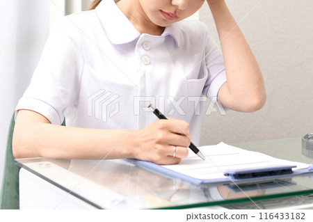 Asian female medical worker worried about writing documents 116433182