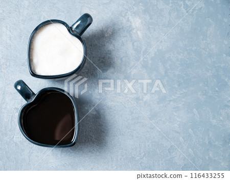 Two cups in the form of hearts with freshly brewed aromatic coffee with milk and espresso  116433255