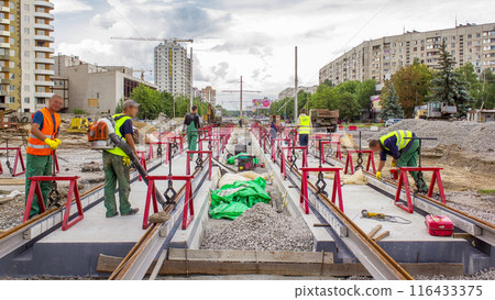 Tram rails at the stage of their installation and integration into concrete plates on the road timelapse. 116433375