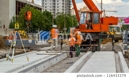 Installing concrete plates by crane at road construction site timelapse. Installing concrete plates by crane at road construction site timelapse. 116433379