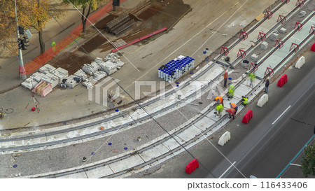 Tram rails at the stage of their installation and integration into concrete plates on the road timelapse. 116433406