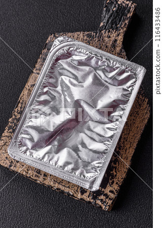 Rectangular plastic box with yogurt or cheese hermetically sealed with a foil lid 116433486