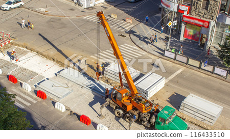 Installing concrete plates by crane at road construction site timelapse. 116433510