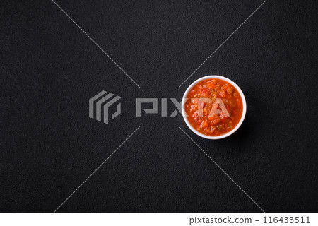 Red hot or spicy sauce with chili peppers, tomatoes, garlic, spices 116433511