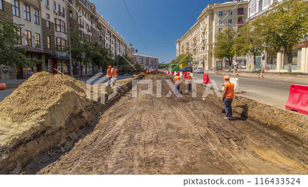 Industrial truck loader excavator moving soil and unloading into a dumper truck timelapse 116433524