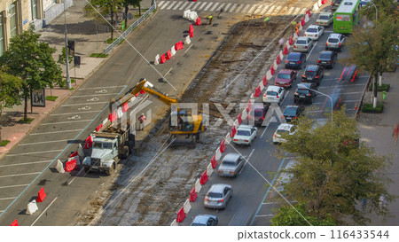 Industrial truck loader excavator moving soil and unloading into a dumper truck timelapse 116433544