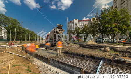 Pouring concrete for road construction with many workers and mixer timelapse Pouring concrete for road construction with many workers and mixer timelapse 116433590
