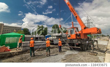 Unloading concrete plates from truck by crane at road construction site timelapse. Unloading concrete plates from truck by crane at road construction site timelapse. 116433671
