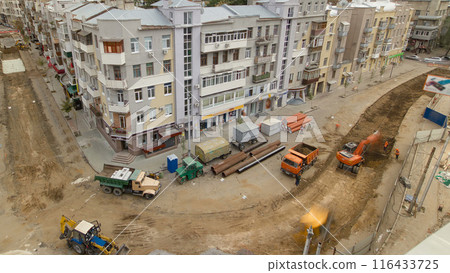 Industrial excavator loading soil material from road construction site into a dumper truck timelapse 116433725