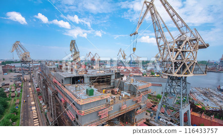The construction of a large ship on a shipyard with cranes timelapse. 116433757