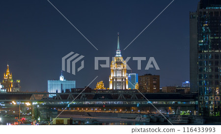 Hotel Ukraine and pedastrian bridge timelapse, landmark near historic center of Moscow. Cityscape in snowy winter evening. Hotel Ukraine and pedastrian bridge timelapse, landmark near historic center of Moscow. Cityscape in snowy winter evening. 116433993