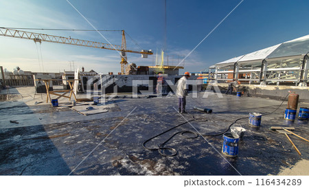 Roofer installing roofing felt with heating and melting of bitumen roll by torch on flame during roof repair timelapse Roofer installing roofing felt with heating and melting of bitumen roll by torch on flame during roof repair timelapse 116434289