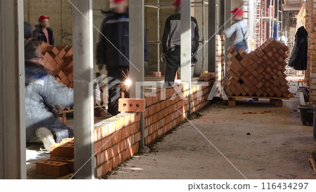 Bricklayers laying bricks to make a walls timelapse. Bricklayers laying bricks to make a walls timelapse. 116434297