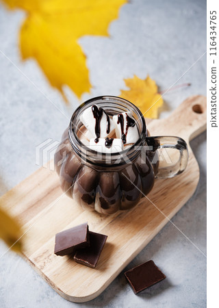 Mug  of hot chocolate with marshmallow  on a cutting board on blue background  116434765